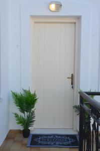 a white door with a plant in front of it at ANIMA family apartment in Naxos Chora