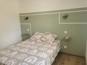 a bedroom with a bed with a white and brown comforter at Maison mitoyenne au cœur du Pays Basque in Saint-Esteben