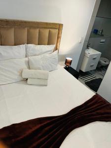 a bedroom with a large white bed with two pillows at Urban Retreat with a View in Windhoek