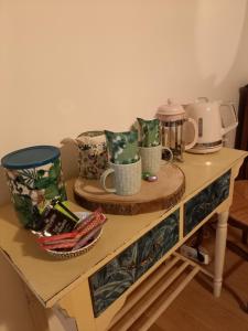 einem Holztisch mit Tassen und anderen Gegenständen darauf in der Unterkunft La Vie du Bief in Bolozon