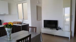 a living room with a table with a vase of flowers on it at White Pearl Apart 5 in Marsaxlokk