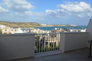 a balcony with a view of the ocean and buildings at White Pearl Apart 5 in Marsaxlokk