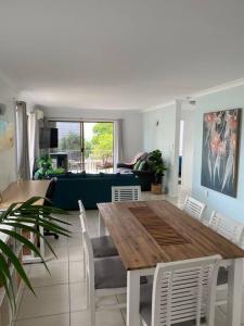 sala de estar con mesa de madera y sillas en Callie Beach Escape - Beachside View, Family Friendly, Walk Everywhere en Caloundra