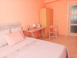 プエルト・デ・サグントにあるFriendly home Bella casaのベッドと机と椅子のある寝室