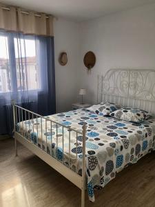 1 dormitorio con 1 cama con edredón azul y blanco en T3 plein centre de Sanary, en Sanary-sur-Mer