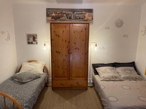 een slaapkamer met 2 bedden en een houten kast bij À 900 M de l'entrée du Circuit des 24 heures in Le Mans