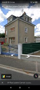 una casa con una valla delante de un edificio en Le Lazare Fleury Orléans calme et proximité, en Fleury-les-Aubrais