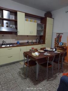 a kitchen with a table and chairs in a room at Mont'Isoro in Orgosolo