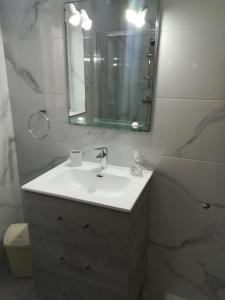 a bathroom with a sink and a mirror at White Pearl Apart 5 in Marsaxlokk