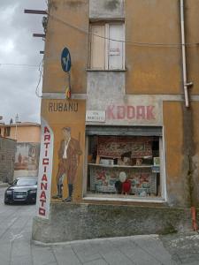 un negozio con un cartello sul lato di un edificio di Mont'Isoro a Orgosolo