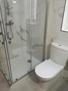 a bathroom with a toilet and a glass shower at White Pearl Apart 5 in Marsaxlokk