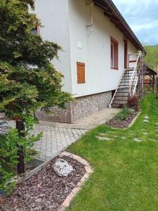 ein weißes Haus mit einer Treppe im Hof in der Unterkunft Ubytko v Rajeckej doline 