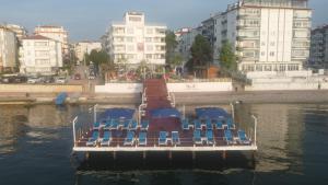 un grupo de sillas en un barco en el agua en Grand Koru Hotel Beach, en Yalova