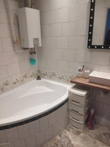 a bathroom with a large tub and a sink at Vip apart in Gorlice