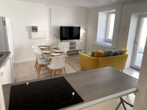 a kitchen and living room with a table and a dining room at Gîte Cadet Roussel - Orgelet in Orgelet