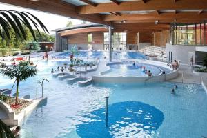 a swimming pool in a building with people in it at Gîte Cadet Roussel - Orgelet in Orgelet