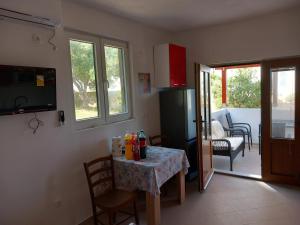 a kitchen with a table and a refrigerator and a room at Apartments Zmaj in Zavala