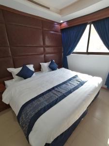 فندق روزلاين في الرياض: غرفة نوم بسرير كبير مع وسائد زرقاء