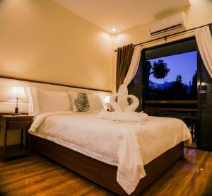 - une chambre avec un lit blanc et une fenêtre dans l'établissement Amigos Dauin Hostel, à Dauin