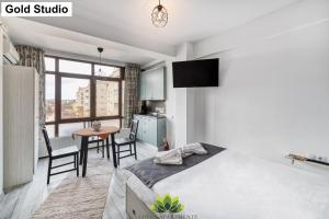 a bedroom with a bed and a table and a kitchen at Cloud Studio in Sibiu