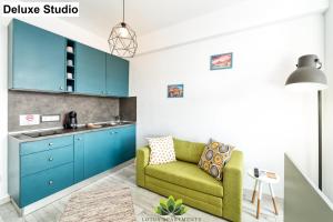 a kitchen with blue cabinets and a green couch at Cloud Studio in Sibiu