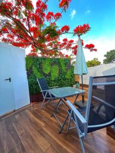 eine Terrasse mit einem Tisch, Stühlen und einem Sonnenschirm in der Unterkunft apartamento in Adeje