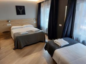 a hotel room with two beds and a window at Hotel Mirtil in Pas de la Casa