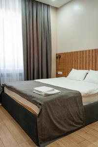 ein Schlafzimmer mit einem großen Bett mit zwei Handtüchern darauf in der Unterkunft BnB Hotel Shymkent in Schymkent