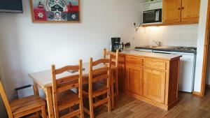 a kitchen with a wooden table and chairs at Résidence Valmonts A, Les Ménuires, appartement 2 pièces in Les Menuires