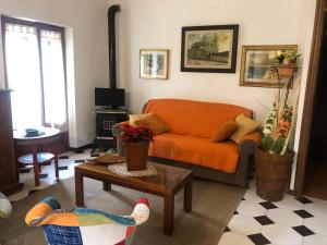 uma sala de estar com um sofá laranja e uma mesa em casale Fossitello em Torre San Severo