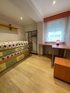 a room with a bed and a desk and a window at Casa Auga Boa Bajo in Cangas de Morrazo