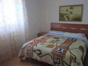 Un dormitorio con una cama con una manta. en SPAZIOSO APPARTAMENTO en Sondrio