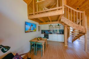 a kitchen and dining room with a wooden staircase in a house at Kaszuby - Komfortowe domki nad jeziorem in Barkocin