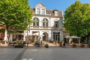 a building with tables and chairs in front of it at Azzuro Living - Cozy Two Bedroom Spot by the Beach & Town by Lion Apartments Sopot in Sopot