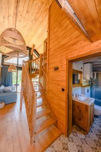 Cette maison en bois dispose d'un escalier et d'un lavabo. dans l'établissement Kaszuby - Komfortowe domki nad jeziorem, à Barkocin
