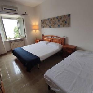 1 dormitorio con 2 camas y ventana en IRIDE sul lago 2 Via Principessa Jolanda 10-Piazza del Molo en Anguillara Sabazia