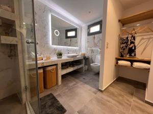 y baño con ducha, lavabo y aseo. en Aphrodite Luxury Accommodation en Mátala