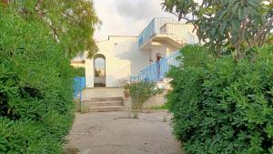 una casa con barandilla azul y escaleras y arbustos en Villa da Patty, en Marausa