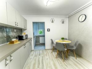 uma cozinha com mesa e cadeiras num quarto em Loghin Residence em Suceava