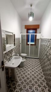 La salle de bains est pourvue d'un lavabo, de toilettes et d'une douche. dans l'établissement Villa da Patty, à Marausa