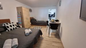a bedroom with a bed and a living room at Holiness Apartmanok in Szeged