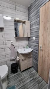 a bathroom with a sink and a toilet at Holiness Apartmanok in Szeged