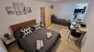 a bedroom with a bed and a living room at Holiness Apartmanok in Szeged