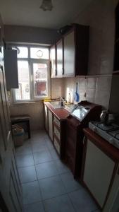 uma pequena cozinha com um lavatório e uma janela em Merkezi konumda daire em Istambul