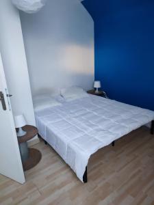 1 dormitorio con 1 cama blanca grande y paredes azules en Le Lazare Fleury Orléans calme et proximité, en Fleury-les-Aubrais