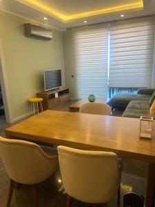 een woonkamer met een grote houten tafel en stoelen bij Kestel Armani Deluxe for a dream life in Alanya