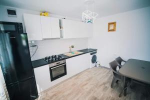 a kitchen with a black refrigerator and a table at Casutele Amaliei in Corbu