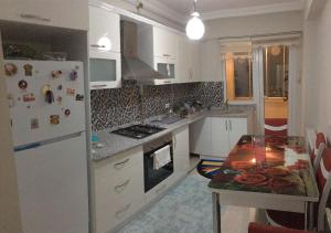 a kitchen with a white refrigerator and a table at Günlük haftalık aylık kiralik eşyalı daire Trabzon Boztepe in Degirmen