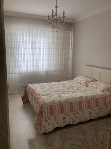 a bedroom with a bed and a chandelier at Günlük haftalık aylık kiralik eşyalı daire Trabzon Boztepe in Degirmen