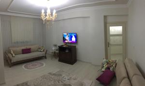 a living room with a couch and a tv at Günlük haftalık aylık kiralik eşyalı daire Trabzon Boztepe in Degirmen